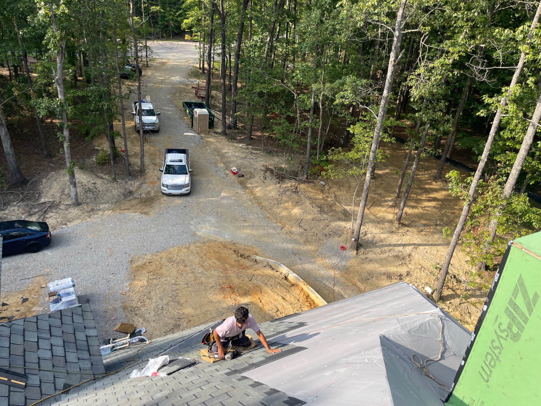 High-angle view of Eagle roofer working near the edge of a large residential roof