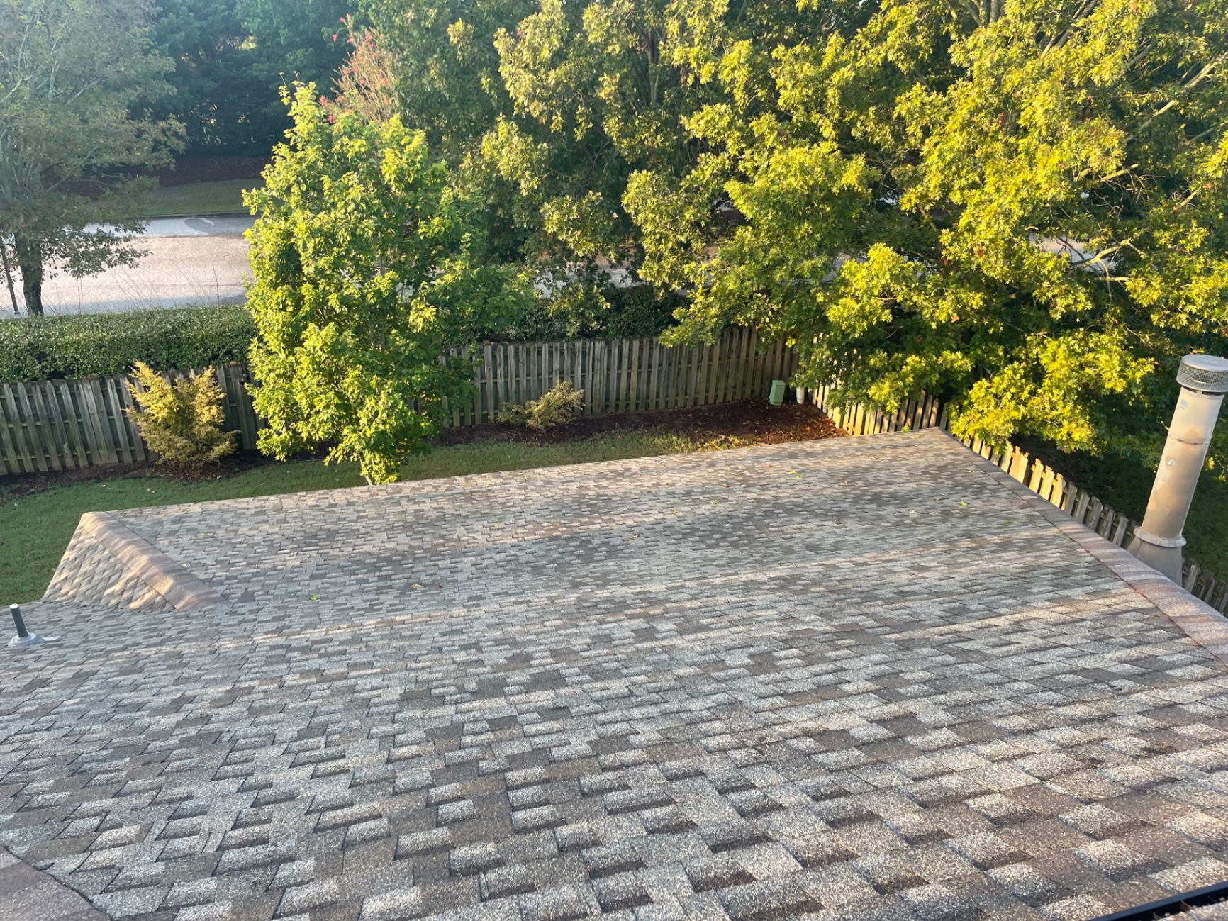 Overview of a low-slope rear roof section with consistent shingle pattern and clean ridge line