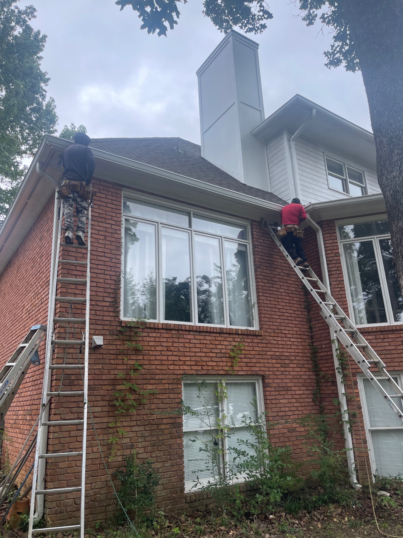 Eagle crew working from ladders on a brick home repair
