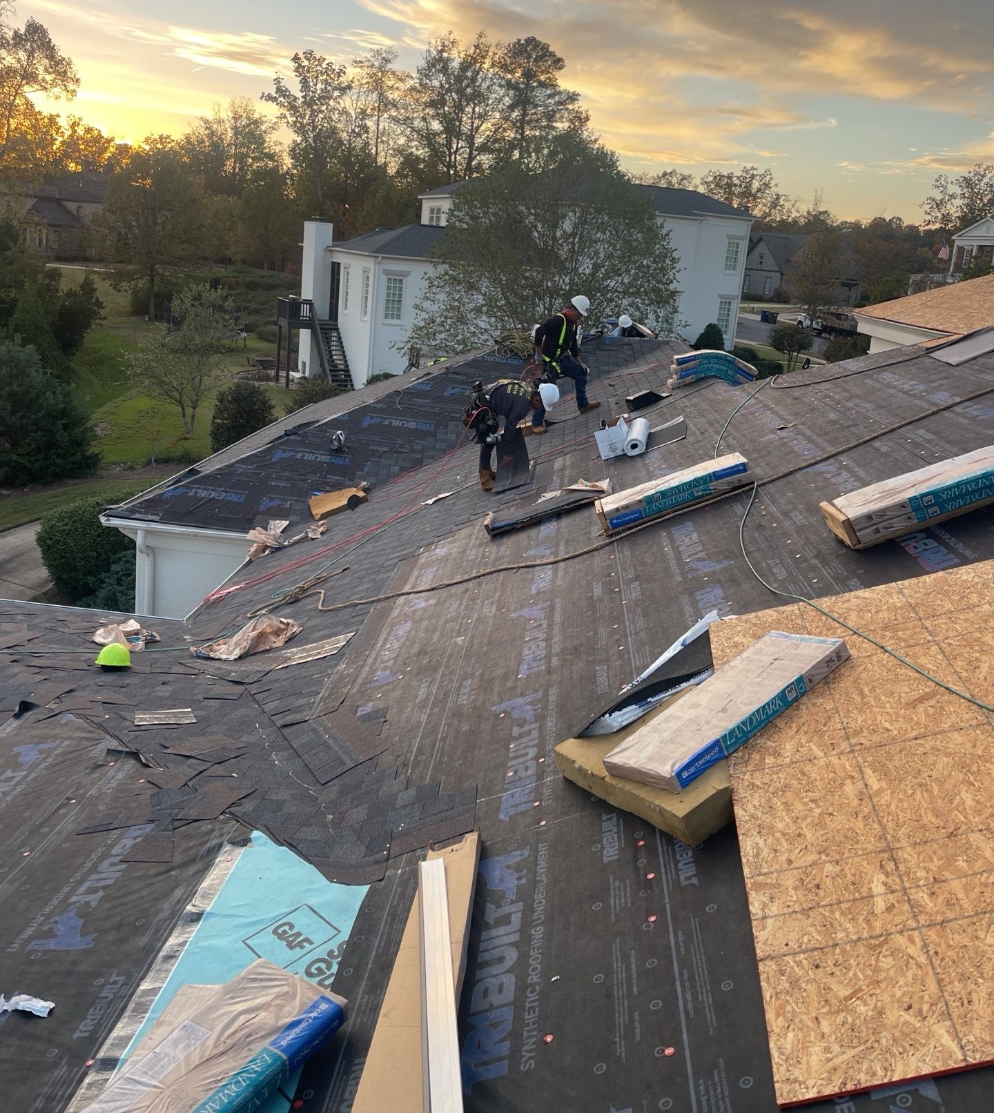 Eagle crew installing a new roof at golden hour during a full tear-off