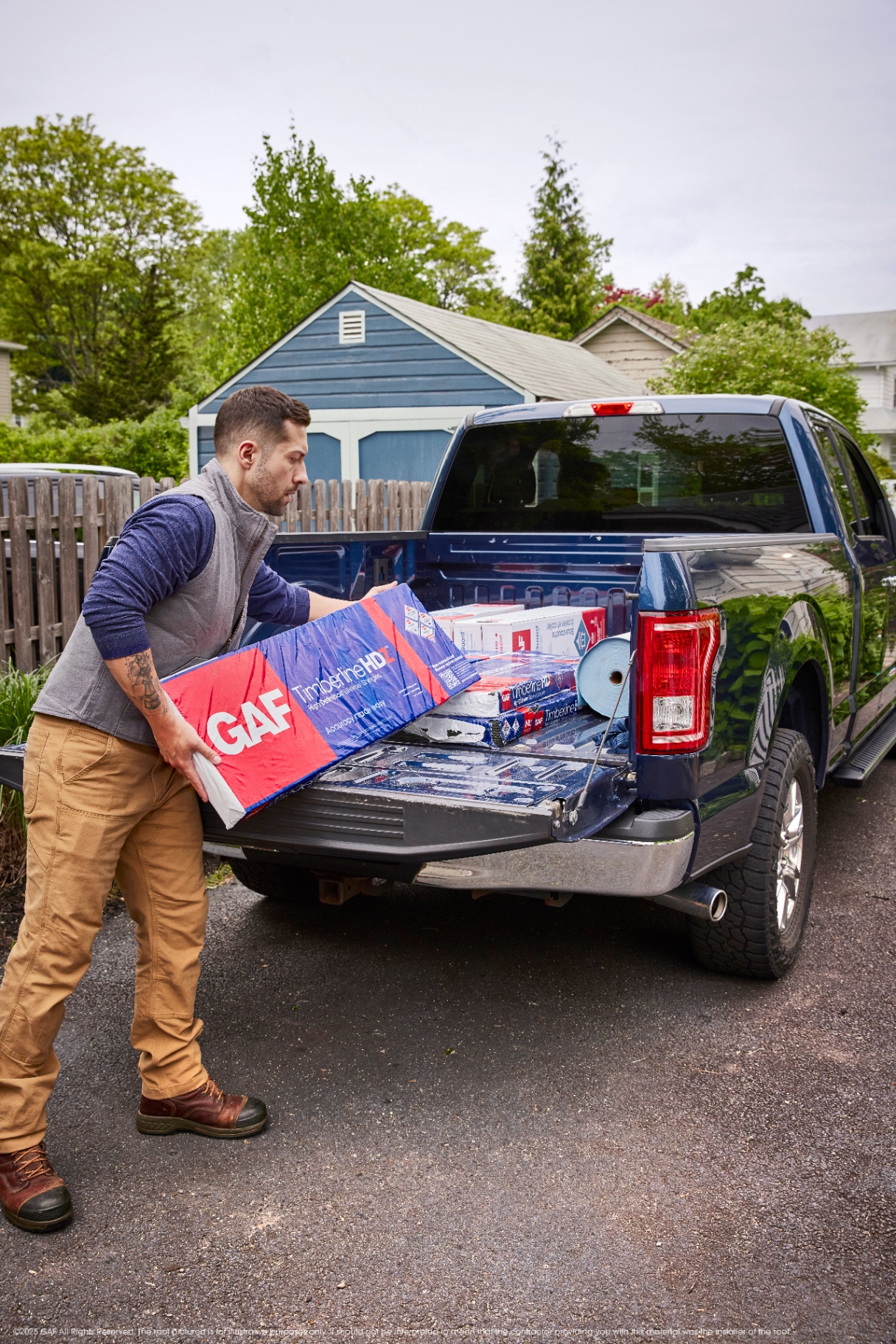 Contractor unloading GAF Timberline shingles from a truck