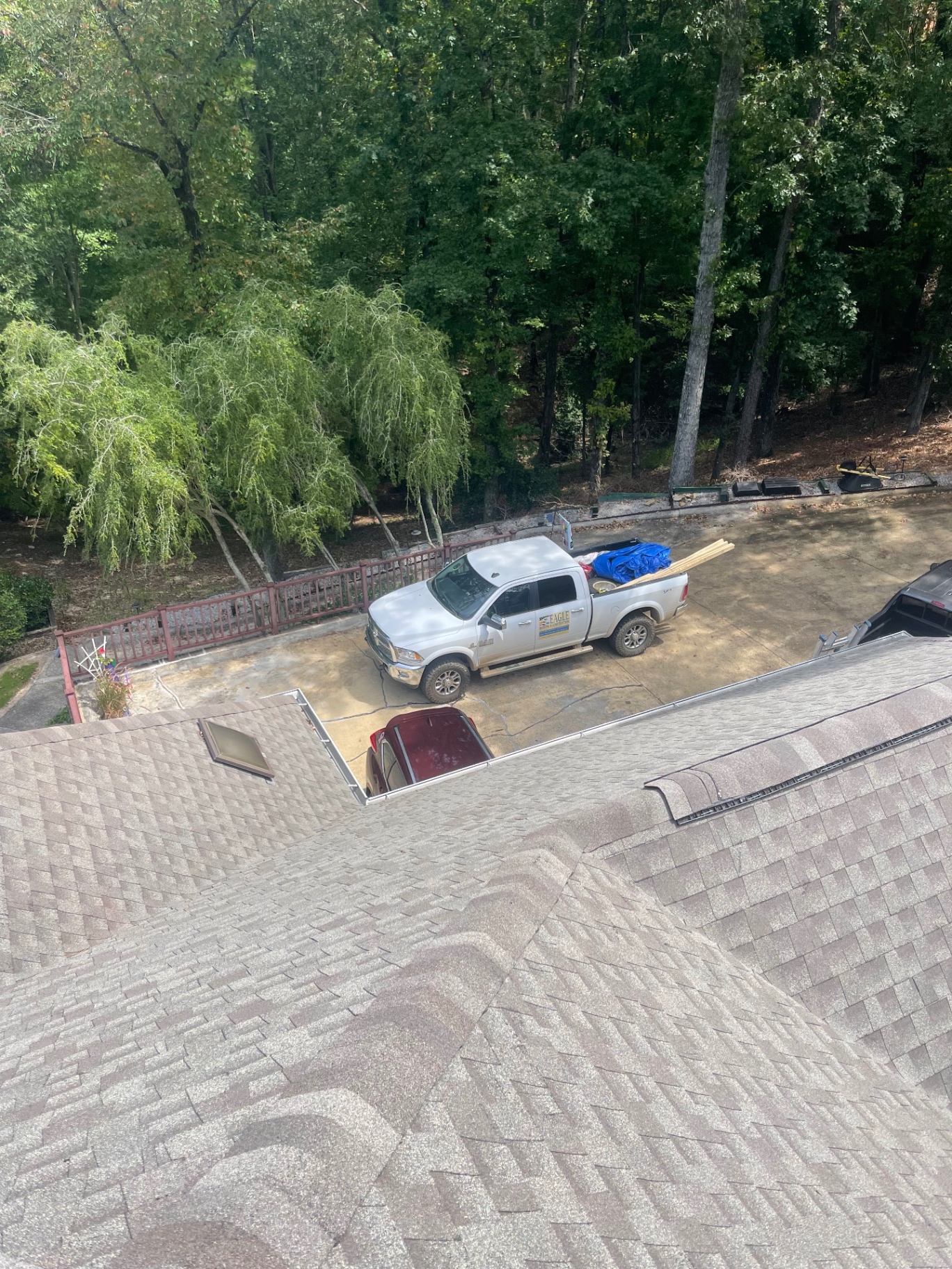 Completed residential roof with Eagle Roofing truck parked in the driveway below