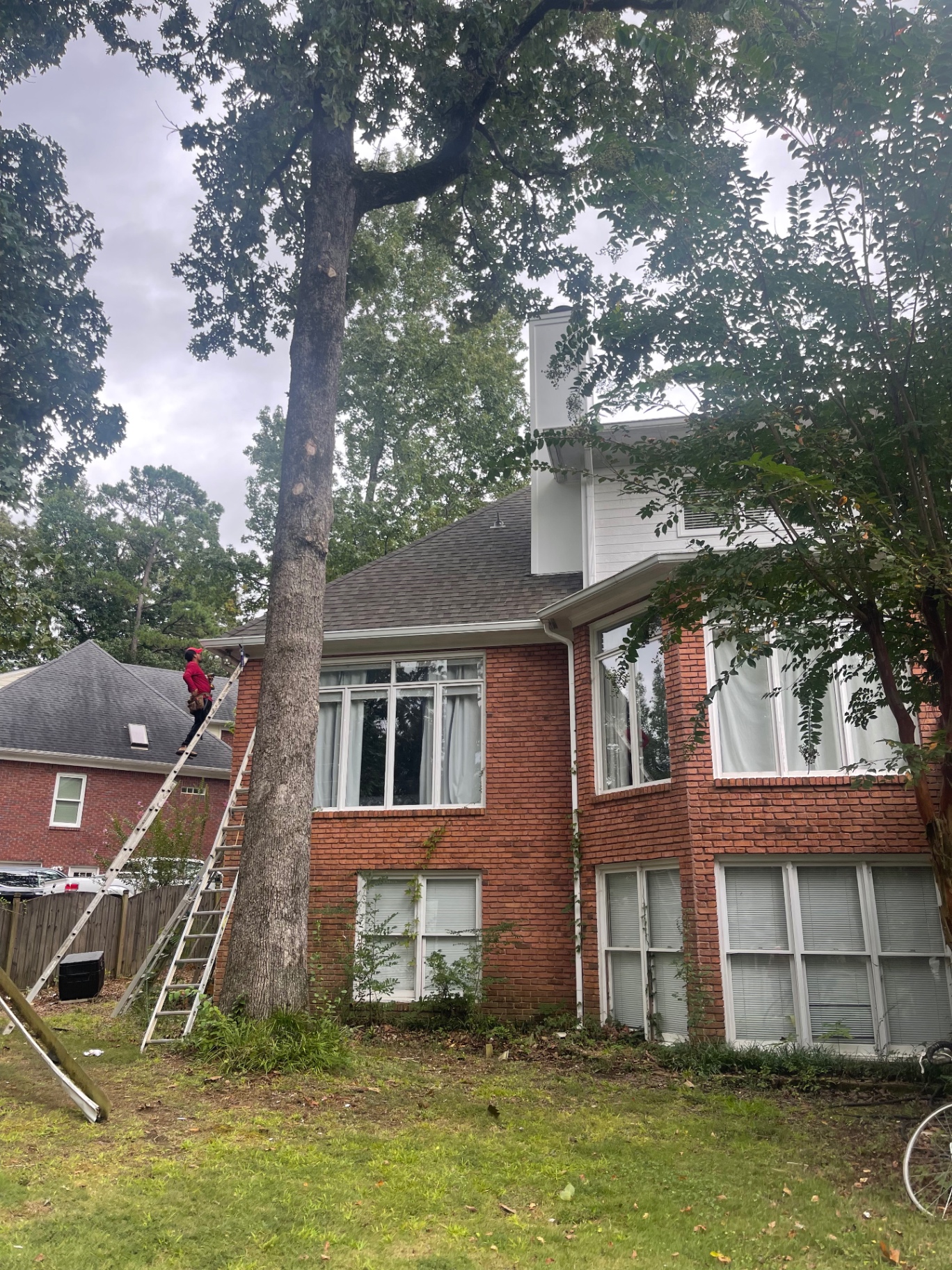 Two-story brick home exterior with completed roof and chimney work