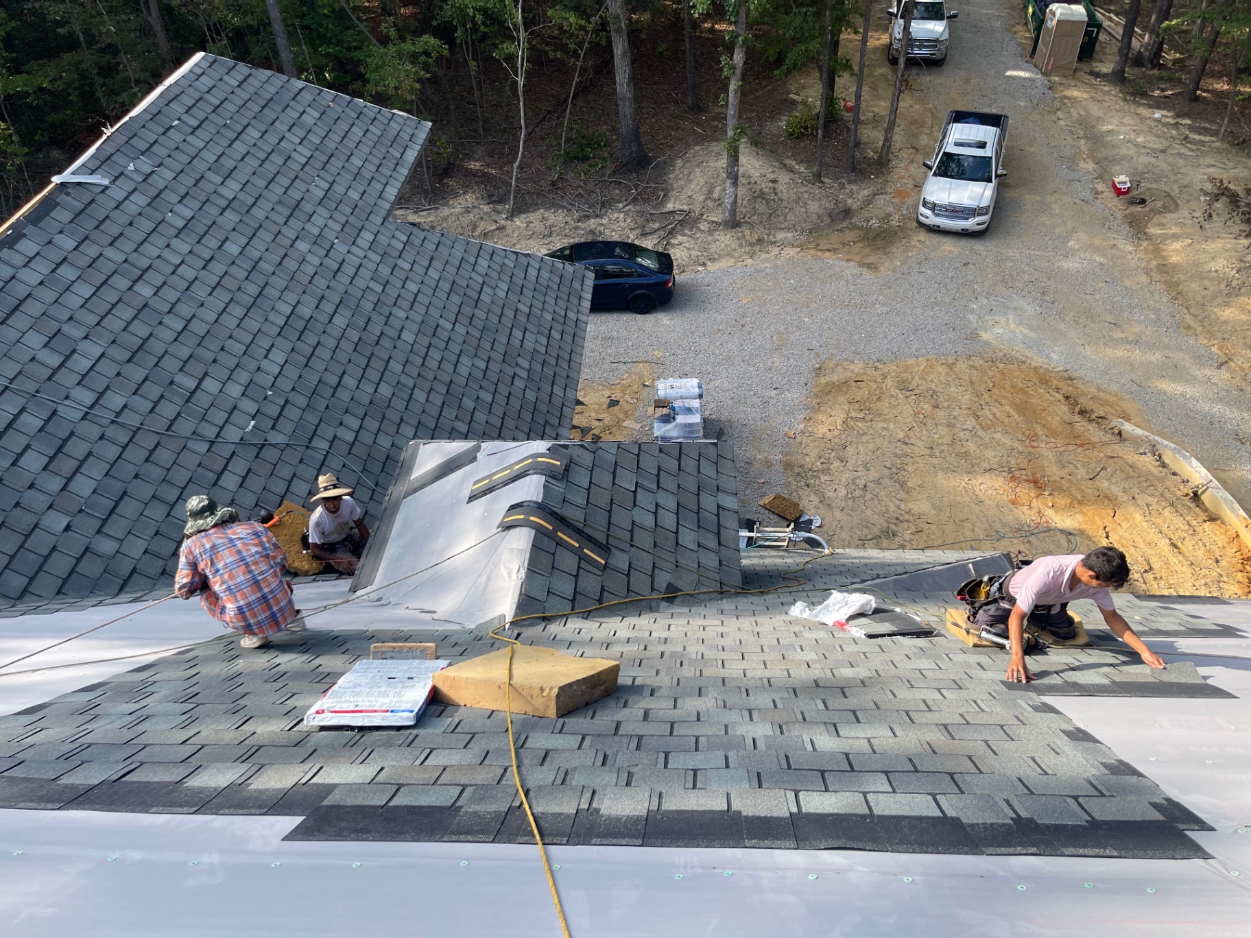 High overview of Eagle crew actively installing shingles across intersecting roof planes