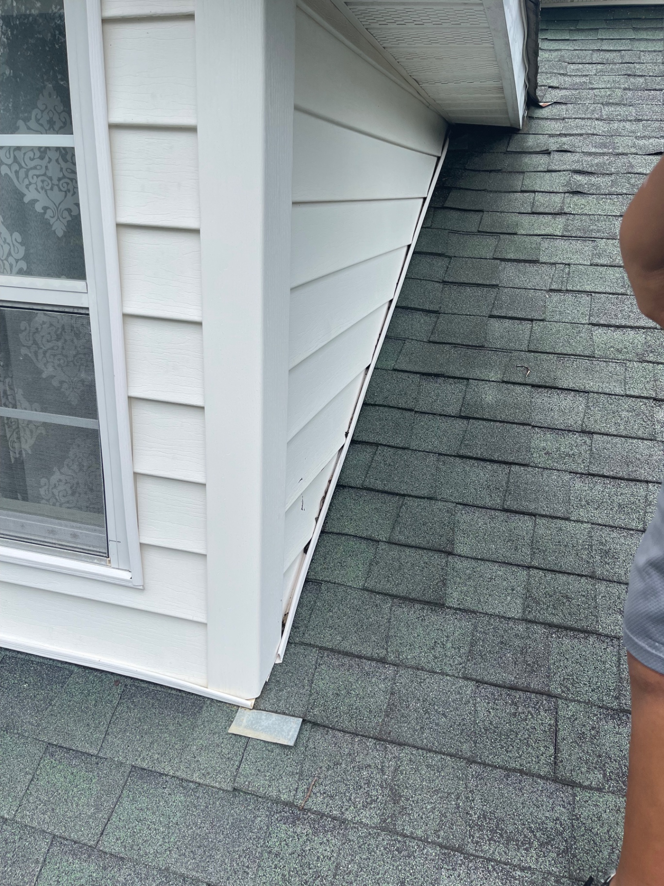 Close-up of dormer sidewall and roof-to-wall transition detail during inspection