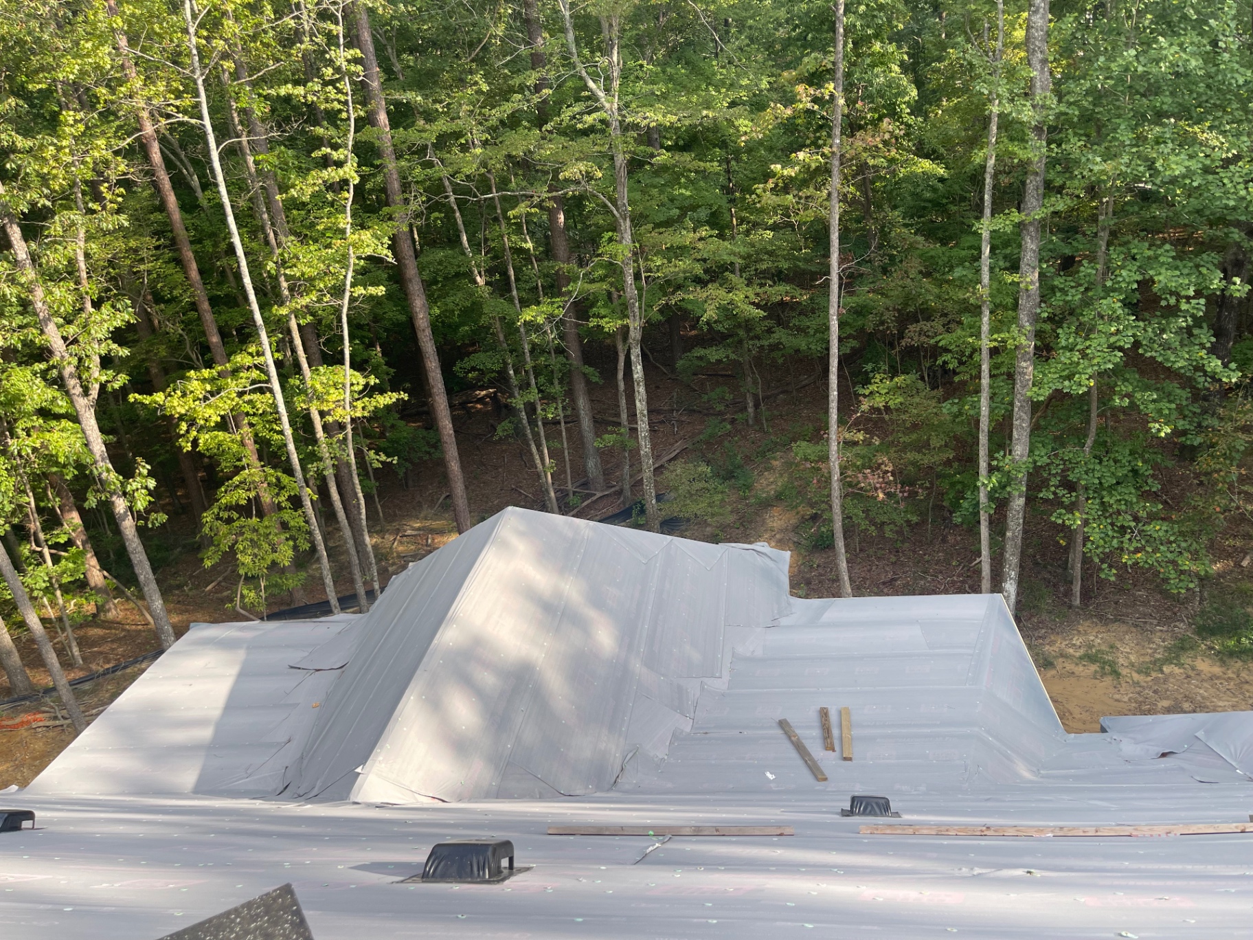 Roof ridge and cricket area covered with protective underlayment before final shingles