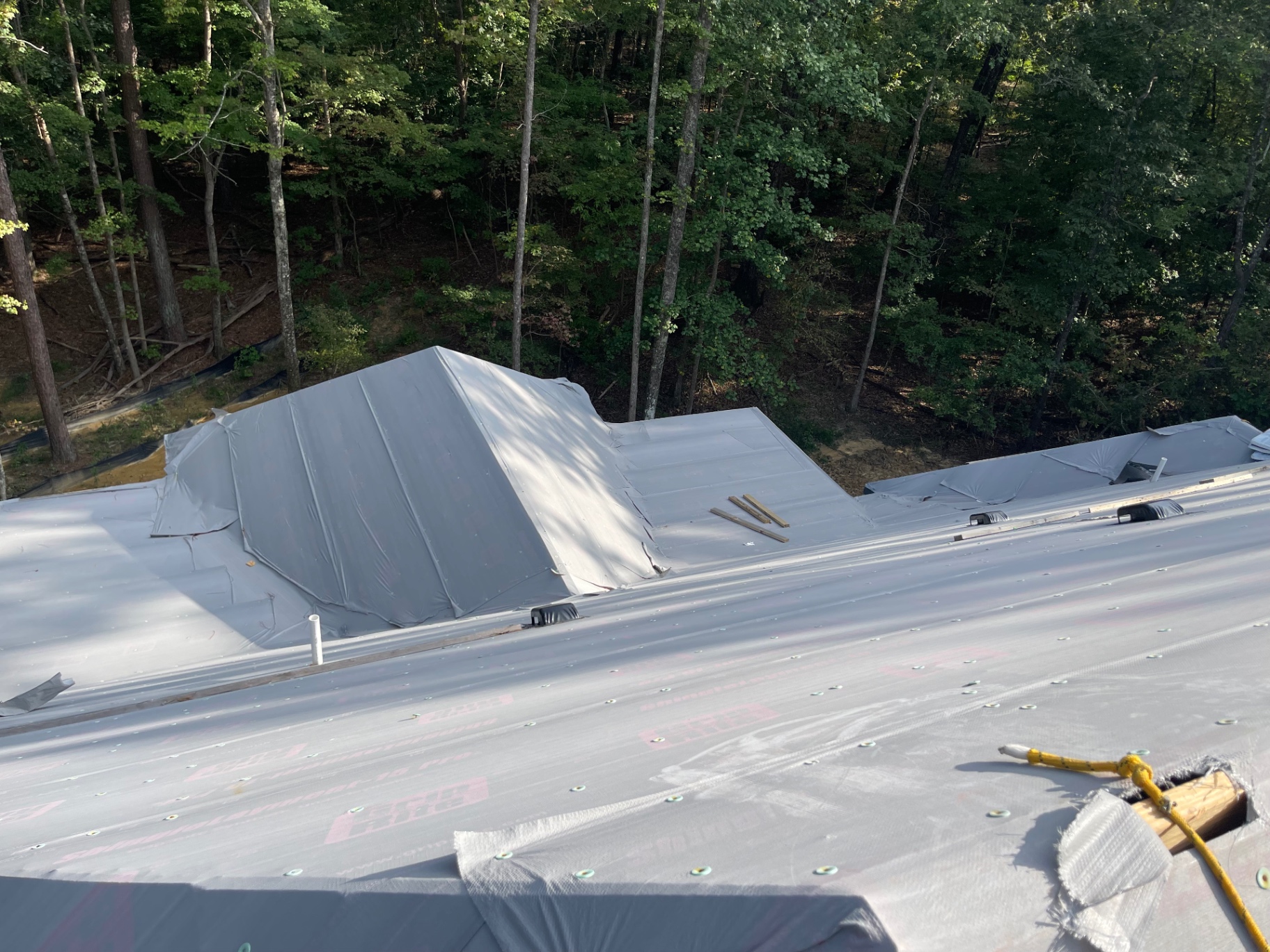 Wide view of roof underlayment and weatherproofing installed across a complex roofline