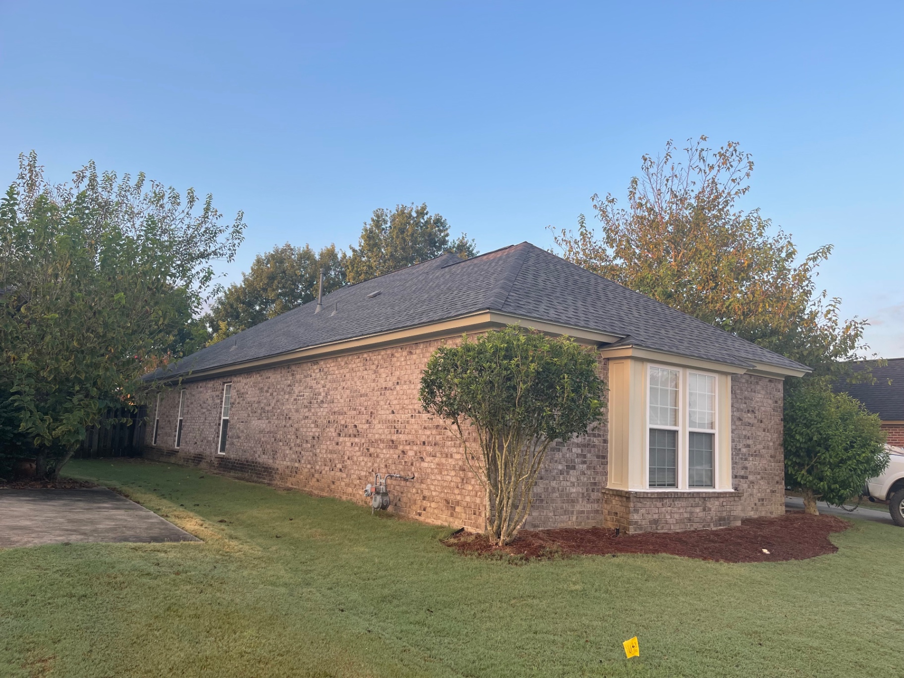 Back corner view of a suburban home with long roof planes and fresh architectural shingles