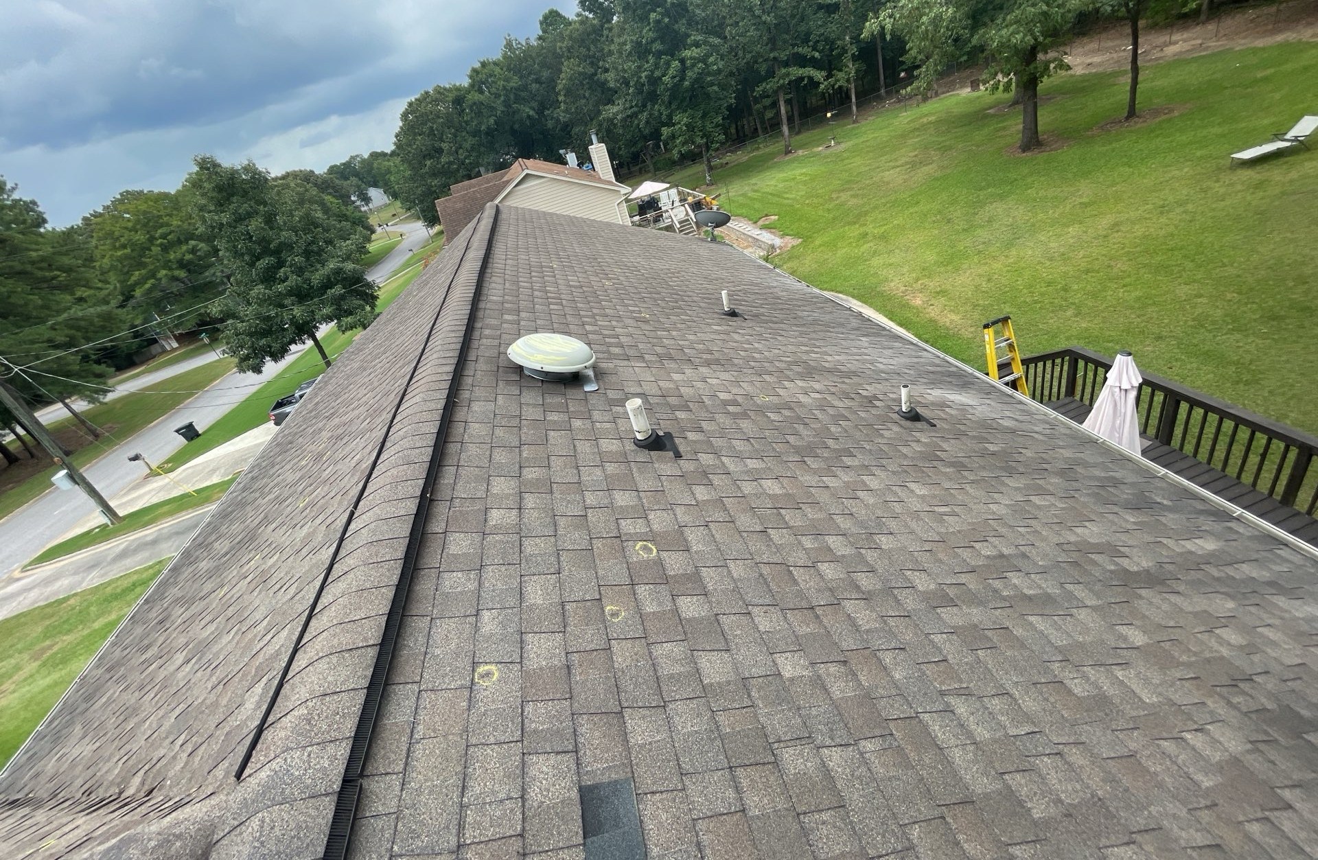 Wide roof inspection view showing hail-marked shingles before replacement
