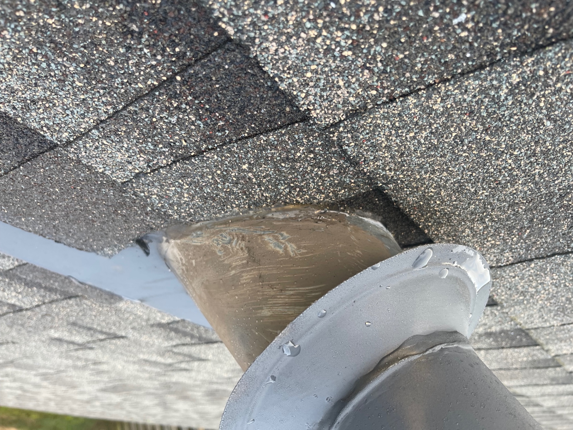 Close-up detail of pipe flashing and sealant work around a roof penetration