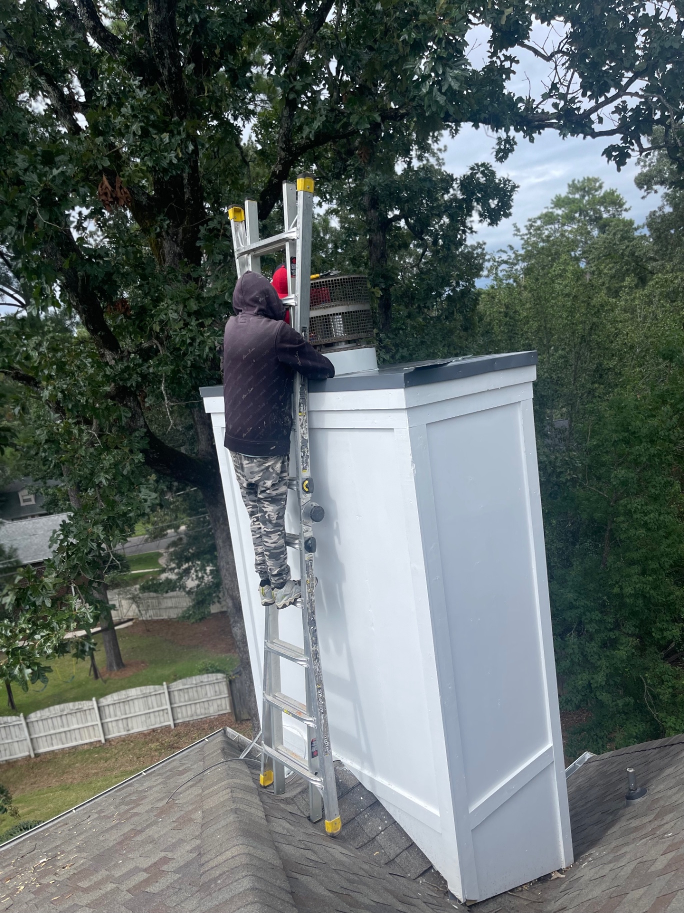 Eagle crew member installing a new chimney cap on a rebuilt chase