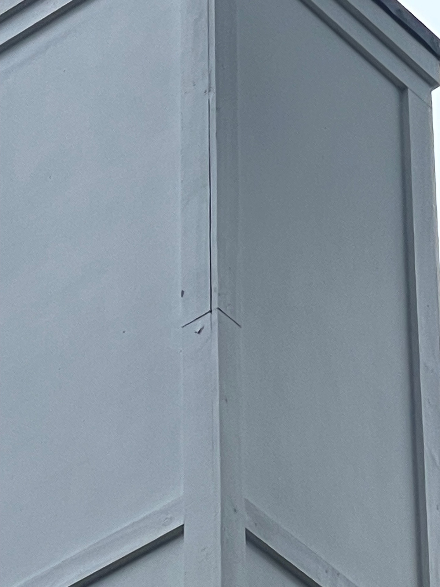 Detail of a repaired and repainted chimney chase corner trim