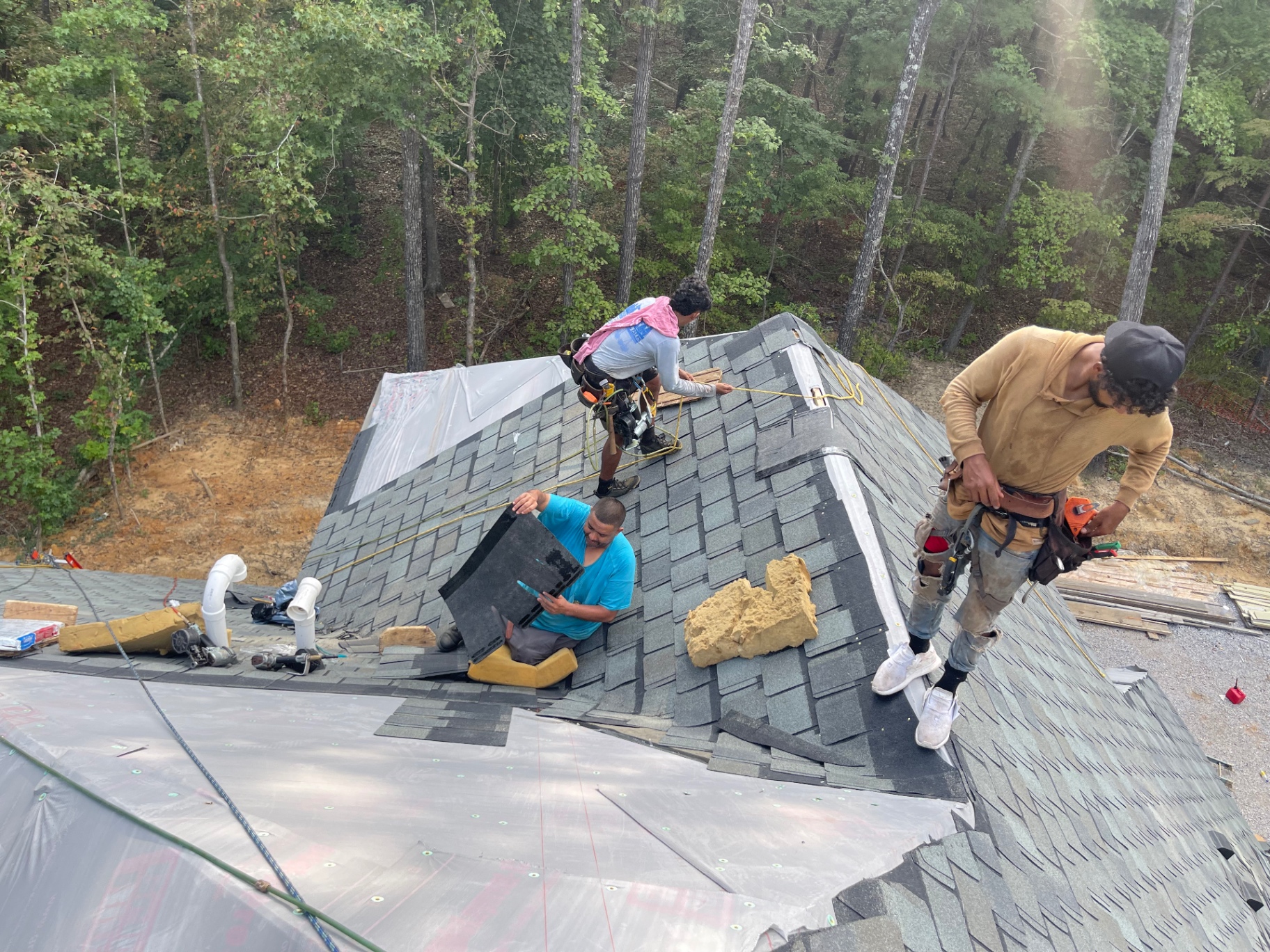 Eagle crew installing shingles and detail work on a hip roof section