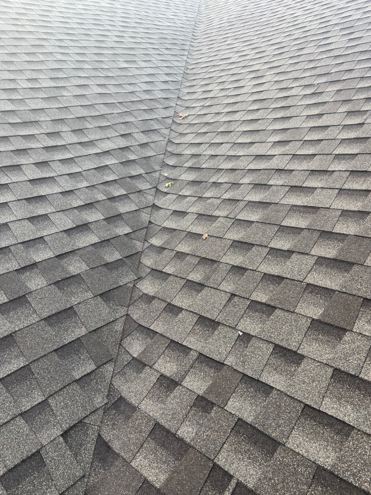 Roof valley overview showing shingle wear patterns and drainage path during inspection
